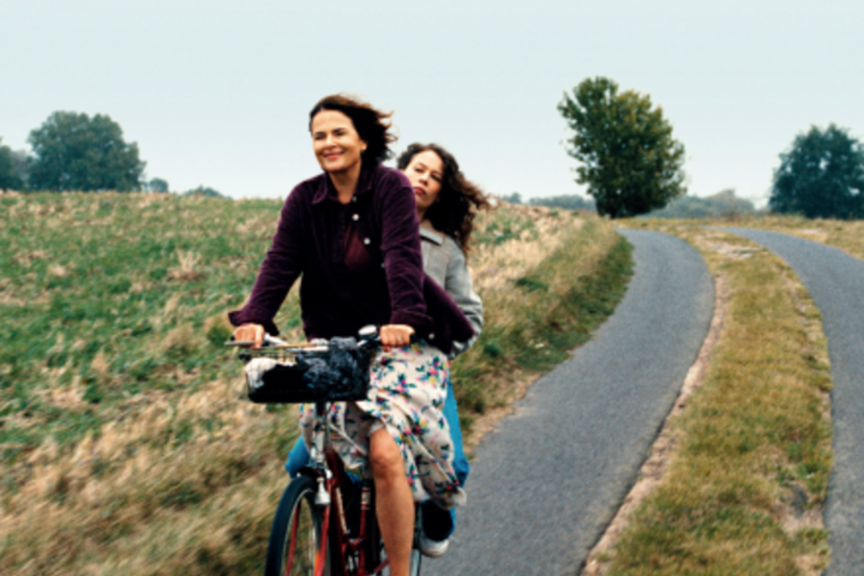 2 Frauen auf einem Fahrrad über Feldweg fahrend, Szene aus dem Film Miroirs No. 3